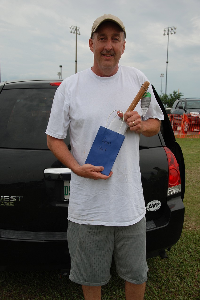 Tim Mccollum holds up his prize of a spatula and $50 gift certificate to Publix after winning second place in the Hamburger Cook-Off.