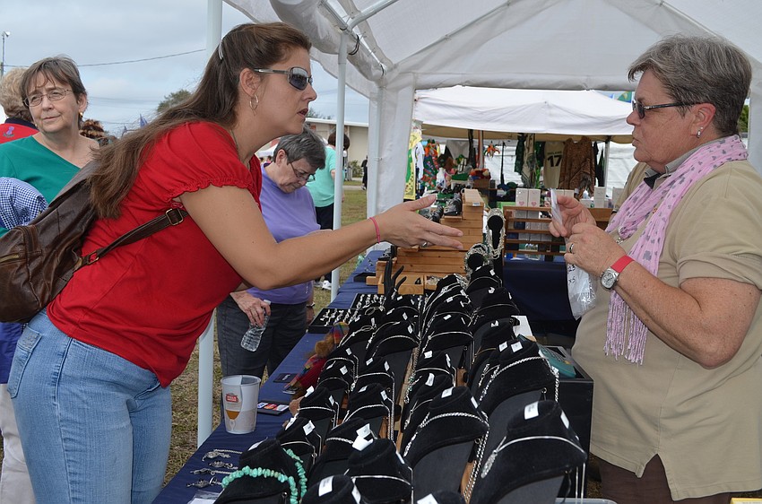 Jessica McQuage buys silver jewelry from Sara Wilson.