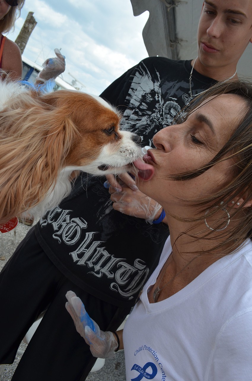 Josephine Eisenberg gets a kiss from four â€“ year â€“ old Gracie after Josh Zollinger helped Eisenberg paint her blue.