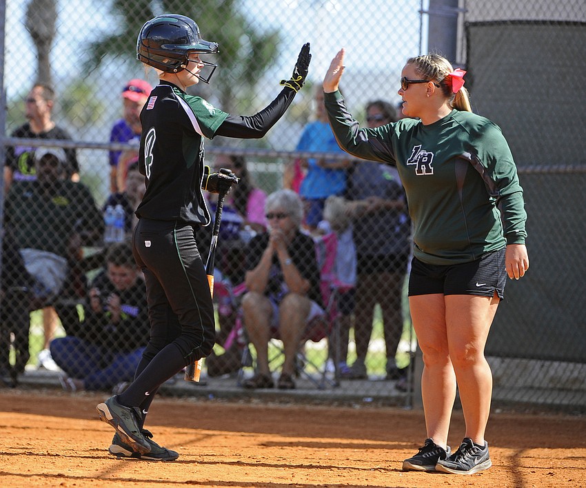 Lakewood Ranch assistant coach Kelsey Grabiak congratulates Amber Wimmer after she scored a run in the bottom of the first inning.