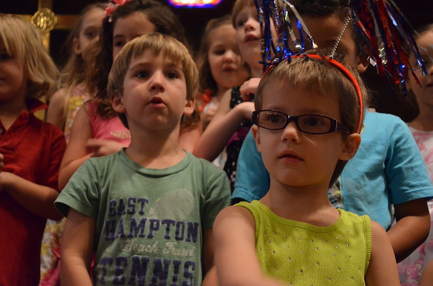 Jonathan Mauro and Isabelle Faucher wait to hear instructions on when to sing for parents.