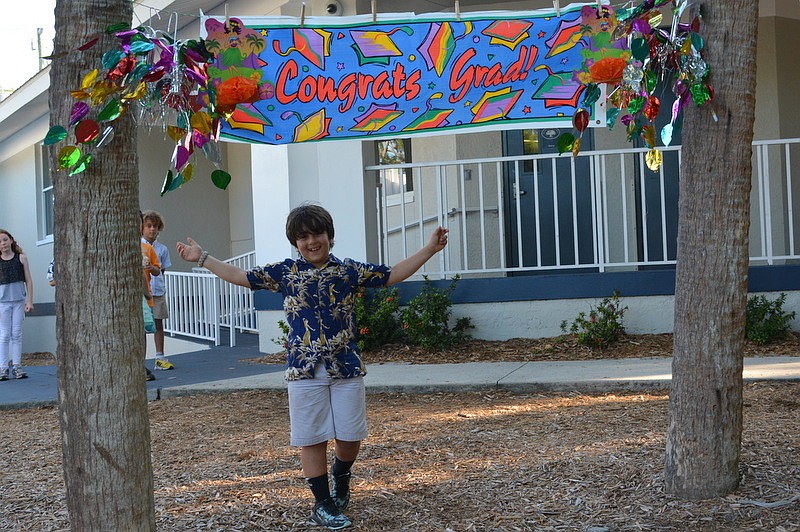 Luca M. crosses the mulch as a symbolic gesture of entering the third grade.