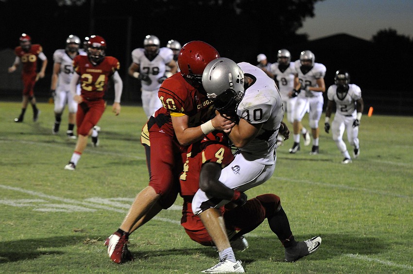 Cardinal Mooney defenders Sam Leonard and Demardre Patterson wrap up Braden River wide receiver Justin Rawlings.
