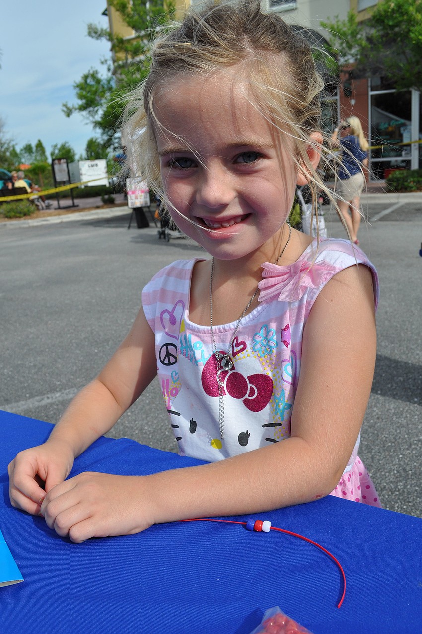 Peyton Kacprzyk, 7, makes a patriotic-colored bracelet.