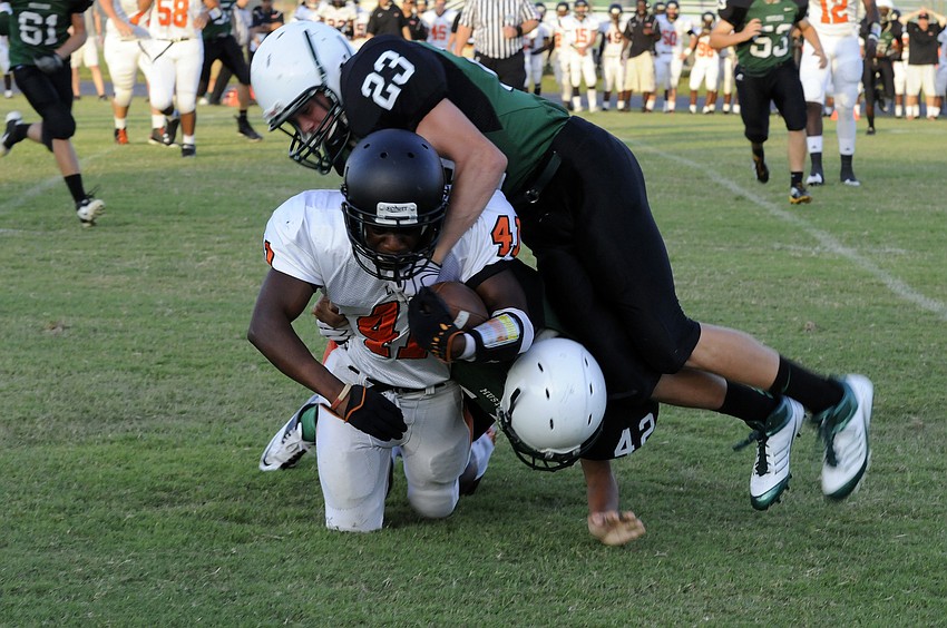 Lakewood Ranch defenders Couper Braun and Julian Rivera wrap up a Naples Lely running back.