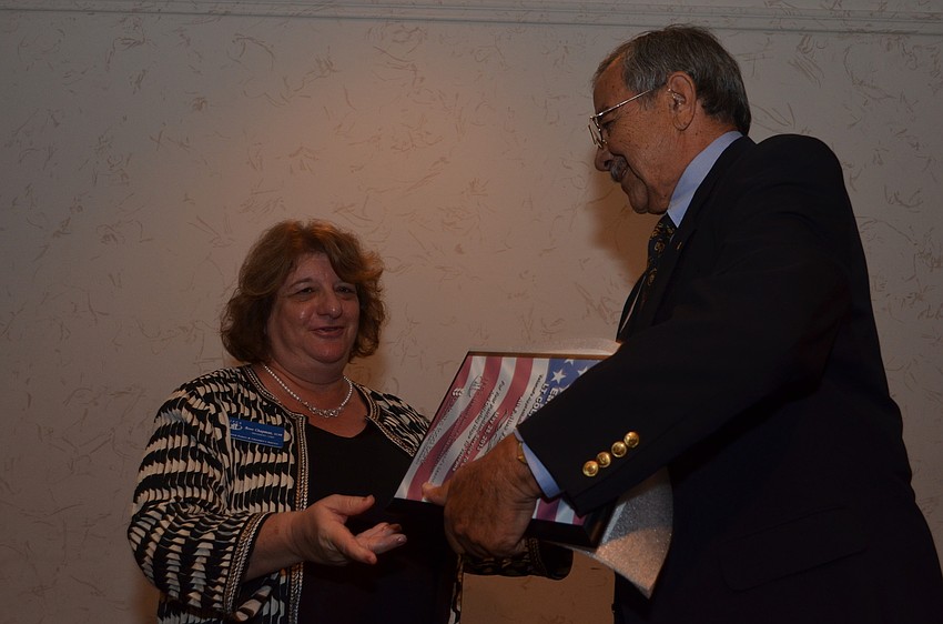Rose Chapman gives veteran Earl Jacobson his award.