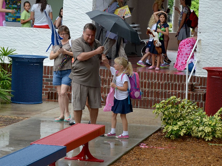 James Armstrong holds an umbrella for his daughter, Katie.