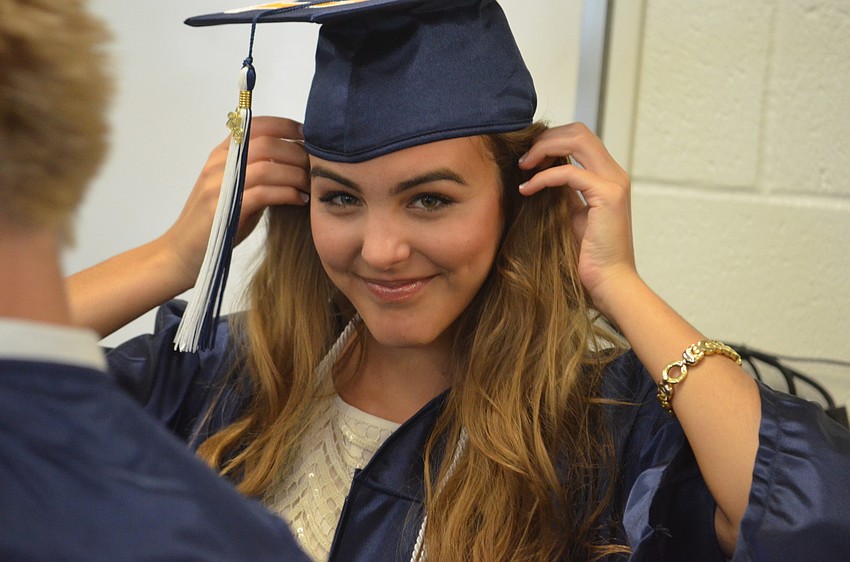 Gabriella Costa adjusts her hair after putting on her cap.
