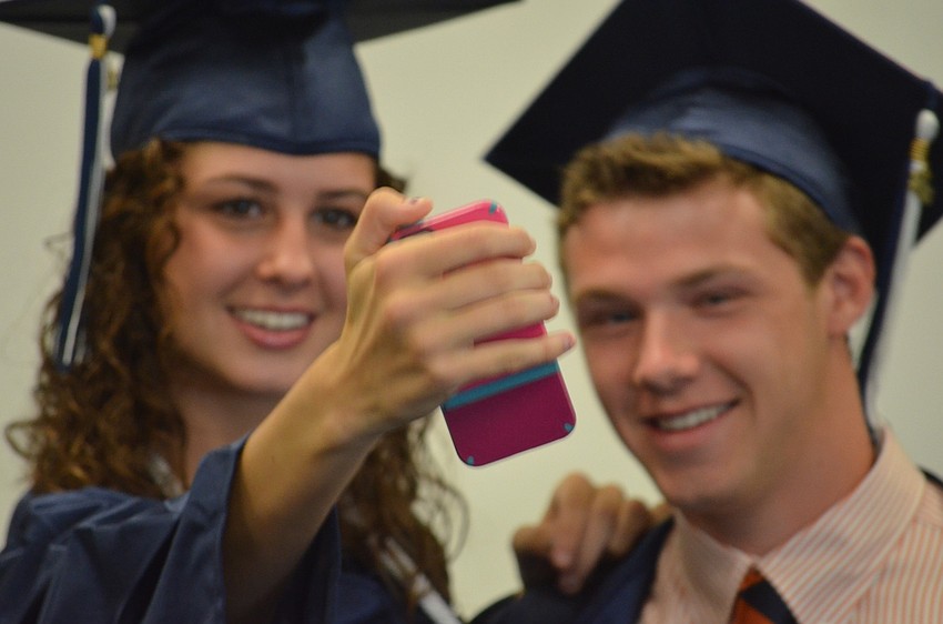Molly McDonald and Sean Kirshe take a photograph together.