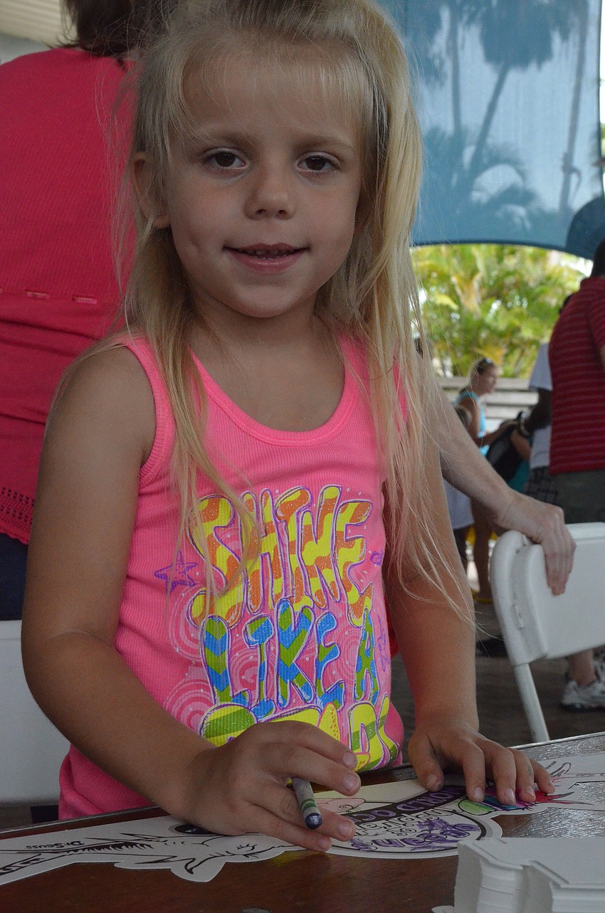 Piper Reynolds, 6, colors at a crafts table.