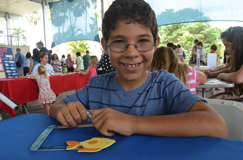 T.J. Smith colors a picture frame made out of popsicle sticks.