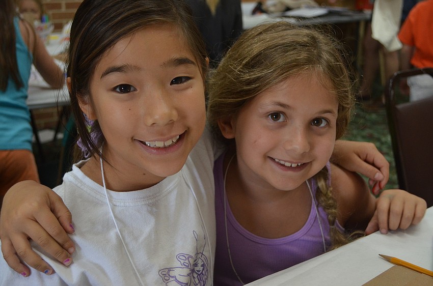 Alexa Horiuchi, 9, colors with her camp mate 7-year-old Caroline Jones.