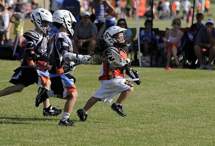 Five-year-old Mickey Cohen breaks past a pair of Bay Area Sand Sharks defenders and heads toward the goal.