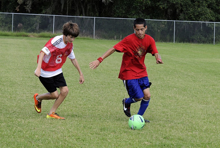 Lakewood Ranch High freshman Julian Warner, right, attempts to maneuver the ball around Haile Middle eighth-grader Justin Novak.