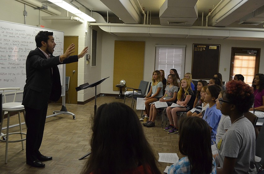 Maestro Jess Martin teaches children how to properly sing in opera.