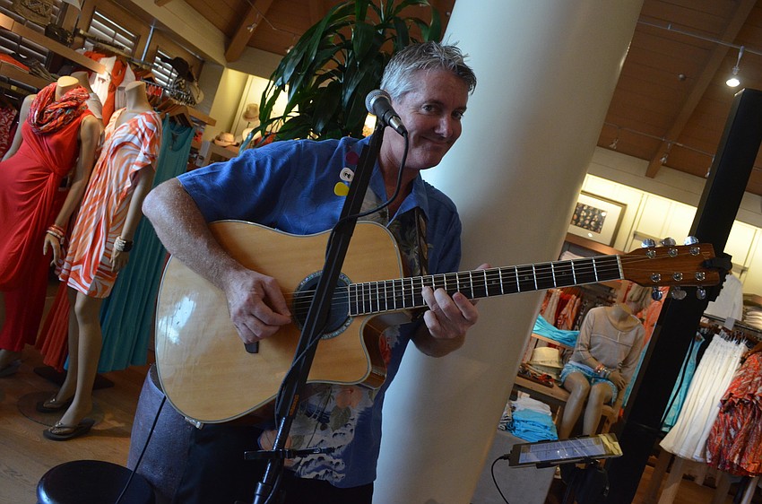 Bain Beakley plays mellow island music on his acoustic guitar for customers.