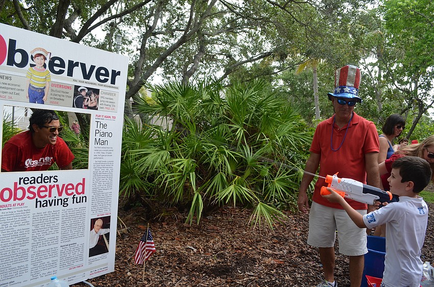 Harrison Troyan, 6, shoots Alex Mahadevan in the face with a water gun.
