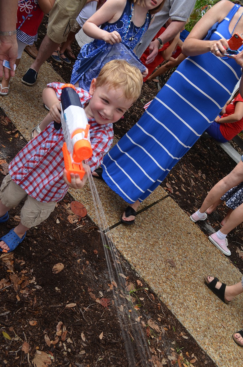 Thomas Carter, 3, blasts Alex Mahadevan with a water gun.