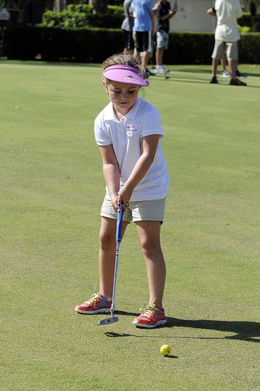 Seven-year-old Emily Mentzer made sure to keep her eye on the ball during putting practice.