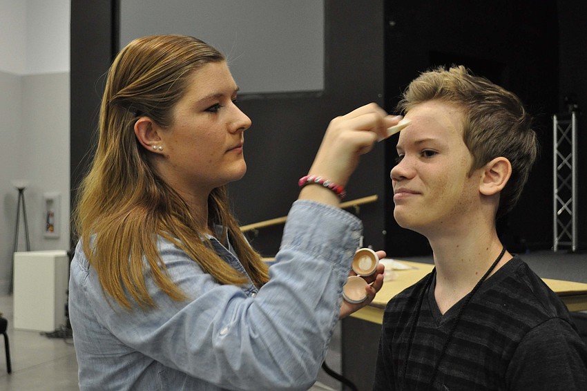 Sarah Martin demonstrates how to apply stage makeup on the face of Chris Bolsinger.