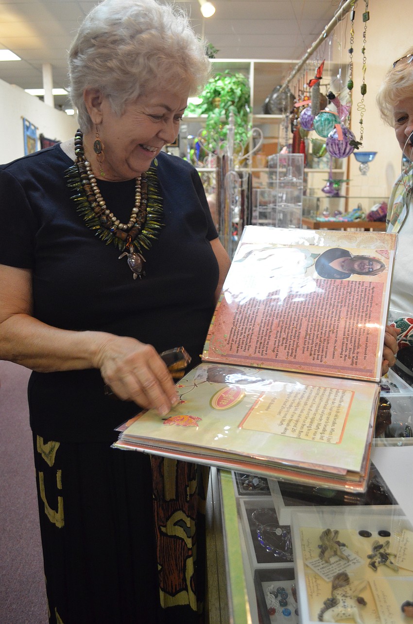 Marty Montague laughs at old photographs of herself.