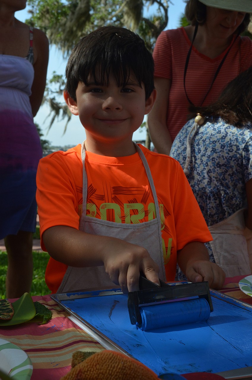Justin Lepow, 5, rolls blue paint over leaves he picked out on his nature tour.