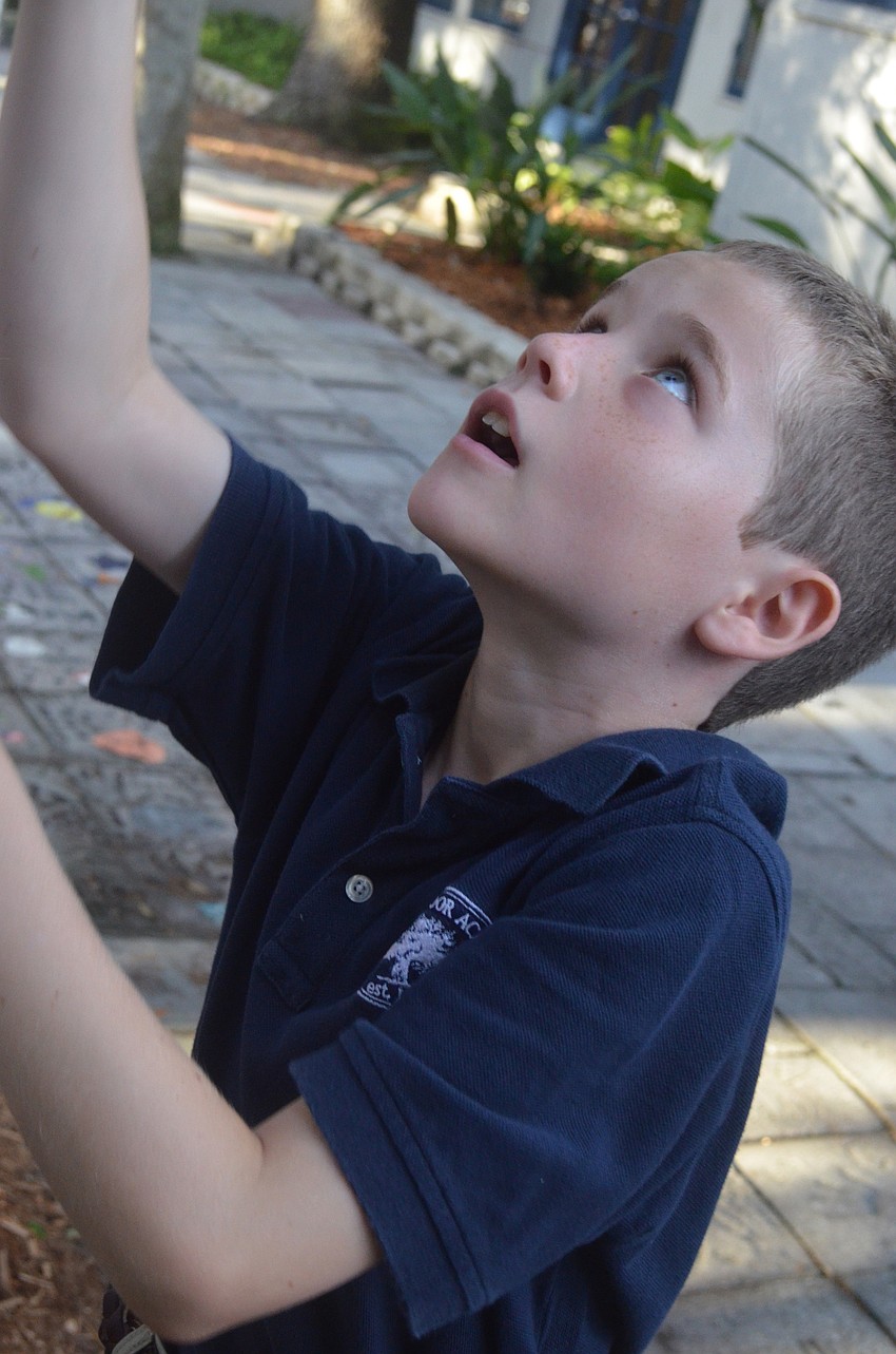 Fourth-grader E.J. R raises the flag before classes begin on the first day of school.