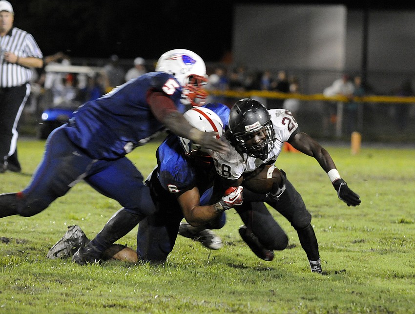 Running back Caleb Ford gains a couple yards before being brought down by a pair of Pinellas Park defenders.