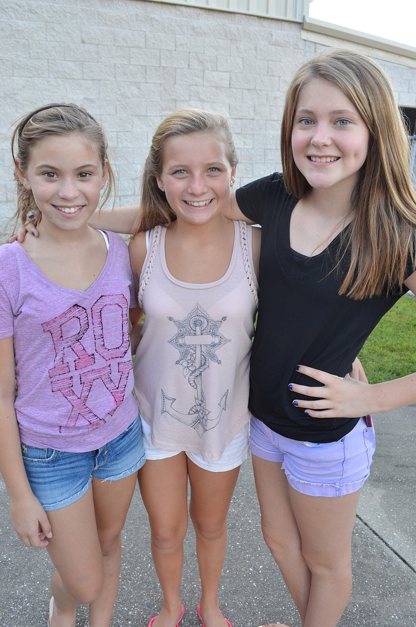 Lauren Hand, 12, Lexy Melone, 12, and Emma Eliason, 12, take silly photos together on their phones.
