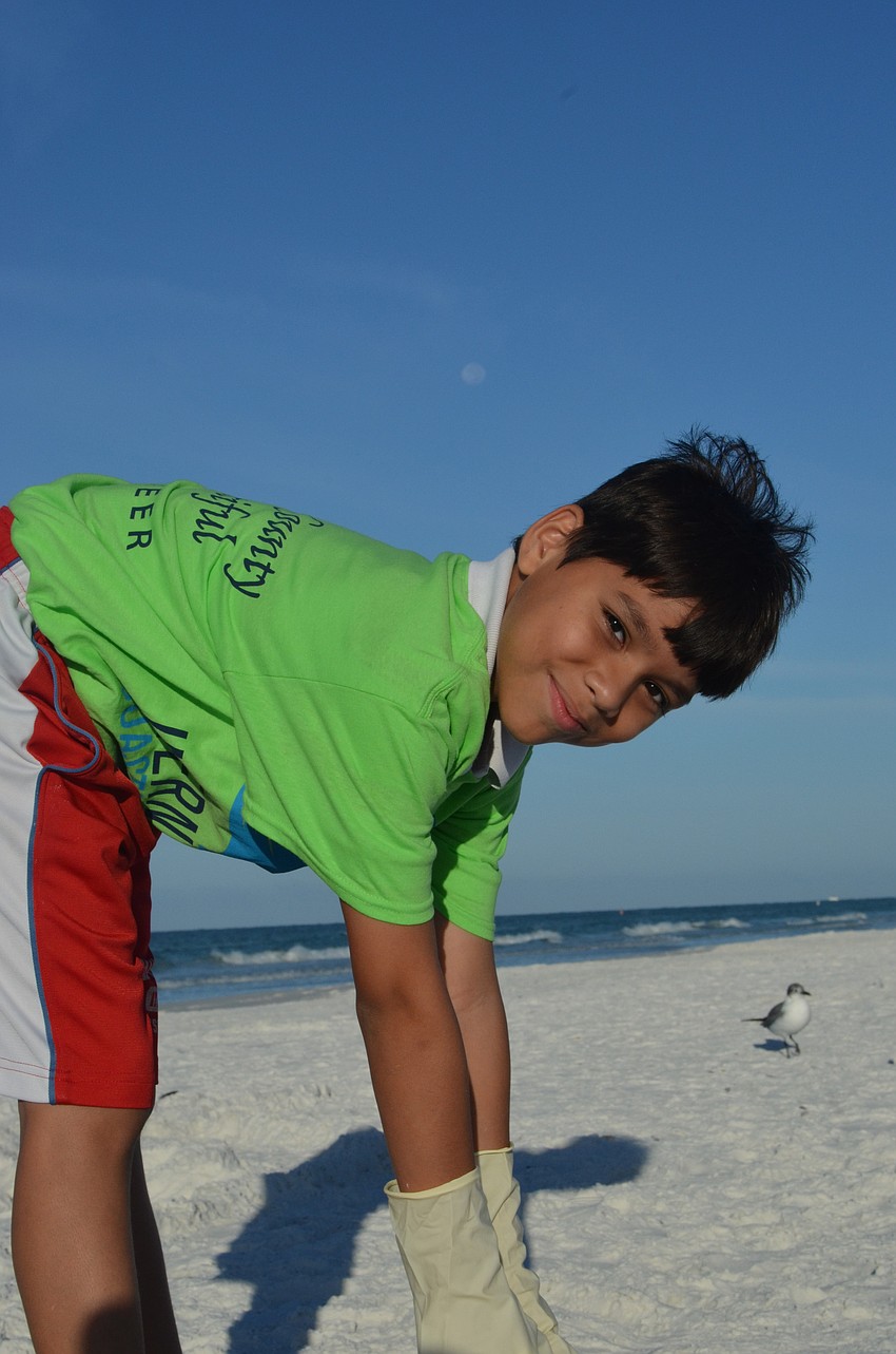 Anthony Gutierrez, 10, picks up trash at the beach.