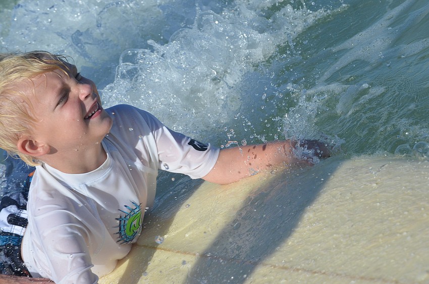 Austin Ezell, 6, rides in on a wave. He jumps up and is ready to go again right after.