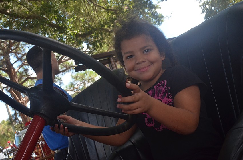 Maddison Smith, 5, takes a seat behind the wheel of an old fire truck.