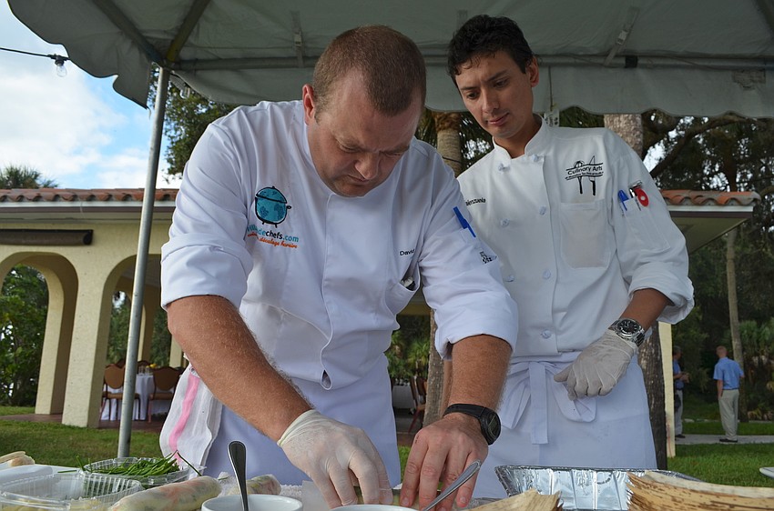 Chef David Lacroix assists MTI student Dante Valenzuela roll spring rolls