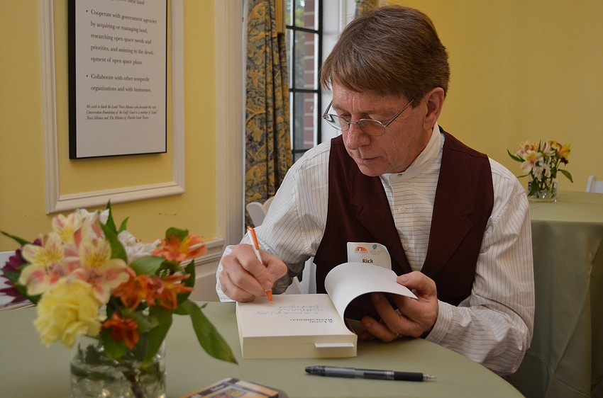 Rick Smith personalizes books for the guests.