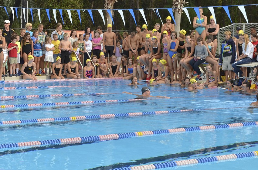 The Sarasota Sharks swim team gathers around the pool while Ryan Lochte talks to them about being a champion swimmer and answers questions the young athletes have.