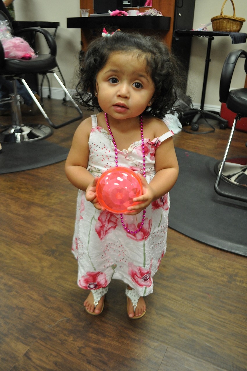 Anabella Perez, 1.5, plays with pink props.