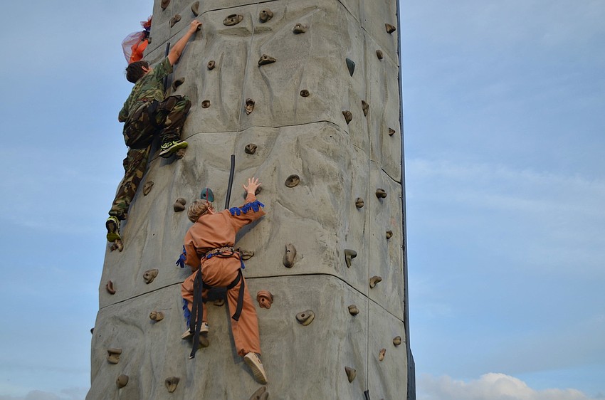 Joshua Pope and Patrick Joice climb the rock wall.