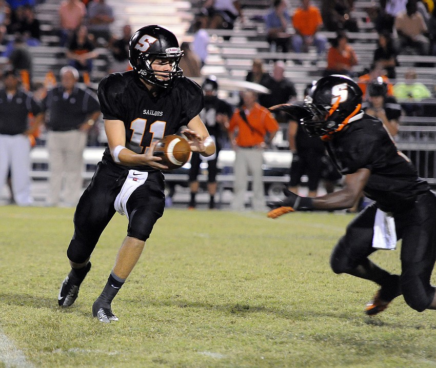 Sarasota quarterback Caulin McNeal hands the ball off to running back Justin Austin late in the first half.