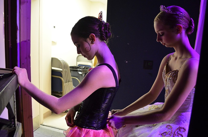 Caitlin Gish (right) tightens Allison Forsythâ€™s costume