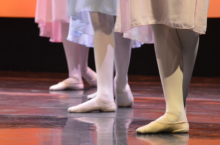 Three dancers block their formation on the stage