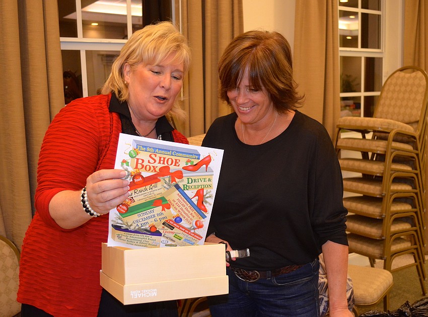 Event coordinator and Meals on Wheels PLUS CEO Maribeth Phillips gives Lori Adam instructions.