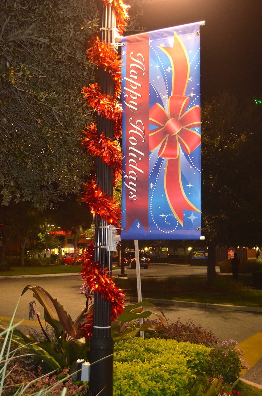 Poles outside the venue feature lights, garland and holiday signs.