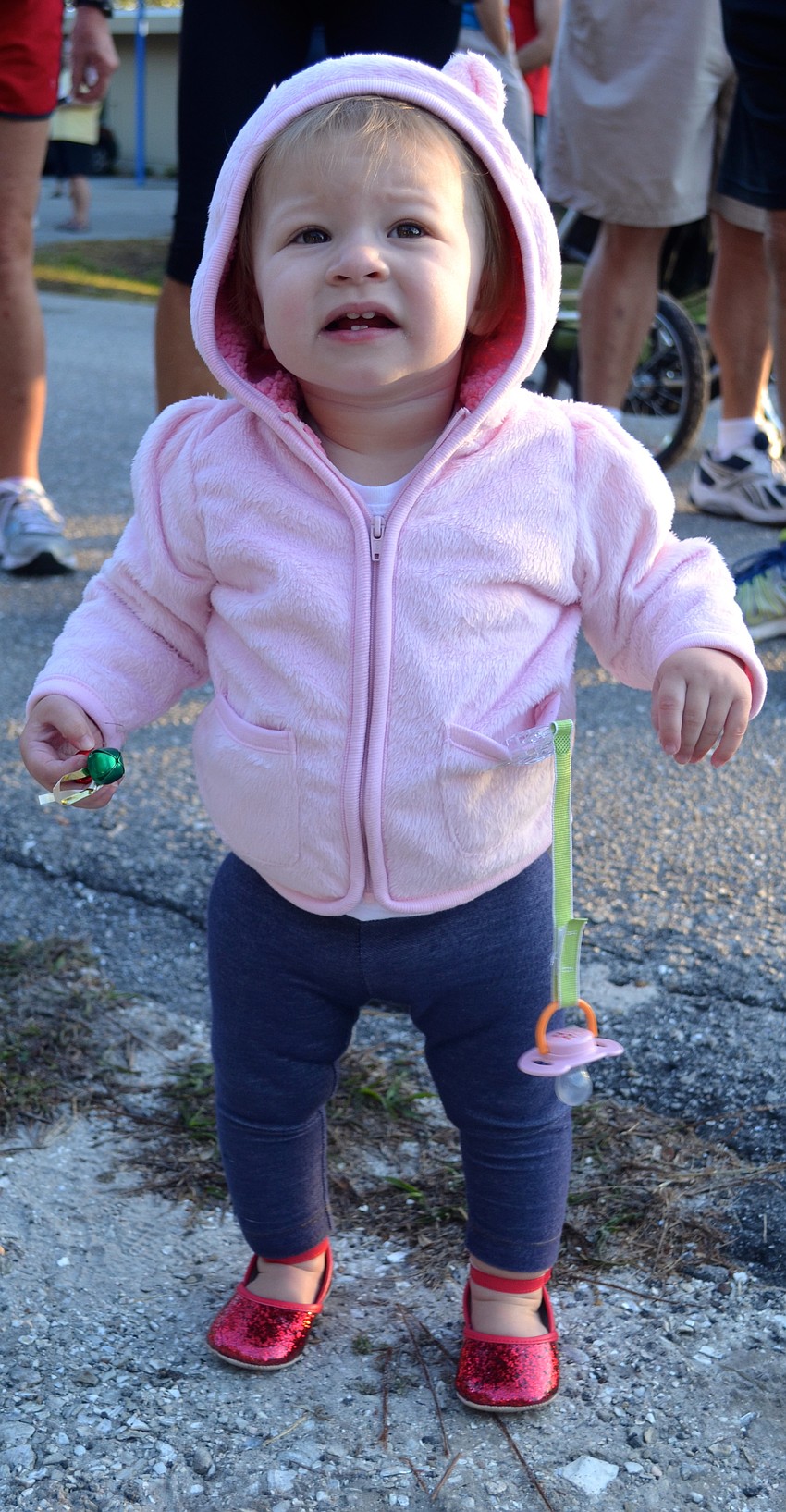 Amy Charlotte Luce, 1, gets in the spirit, grasping a jingle bell.