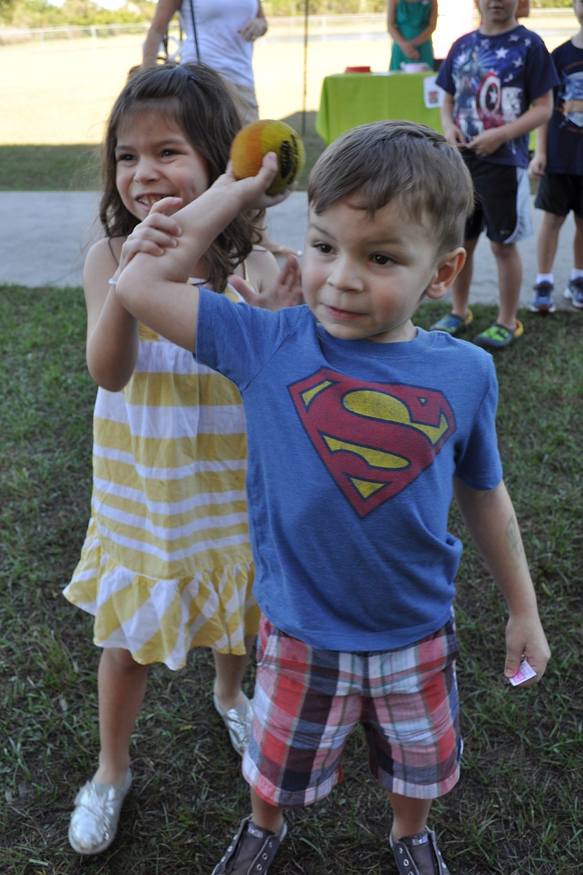Arianna Liemann, 5, helps her brother, Adrian, try to get a teacher drenched in slime.