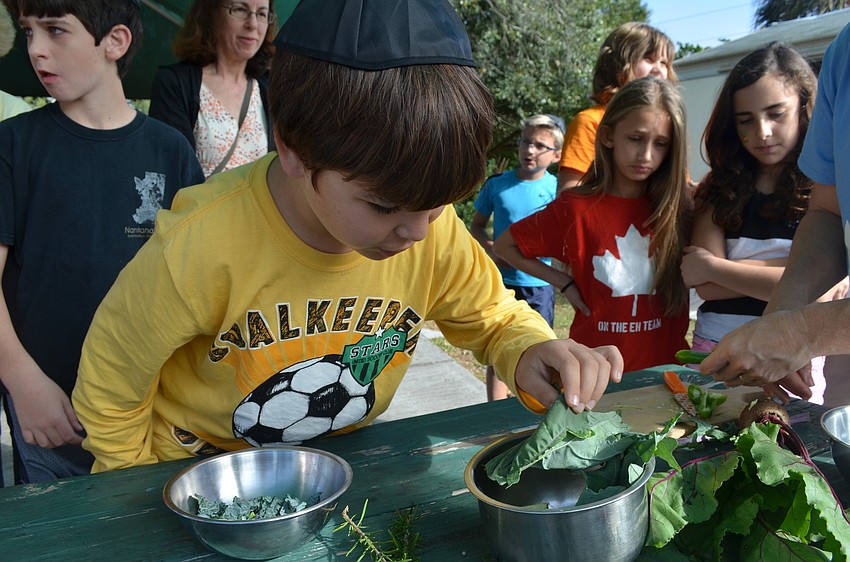 Nati Mizrahi tries some kale from the organic garden.