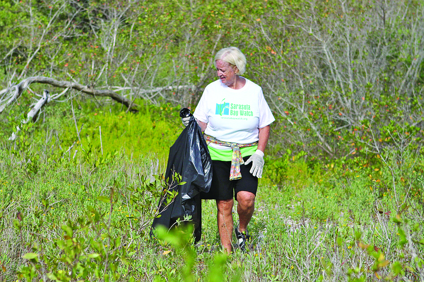 Betsy Falls searches for trash May 11 at the fifth annual Sarasota Bay Watch Sister Keys Cleanup. Volunteers collected a ton of trash. 3