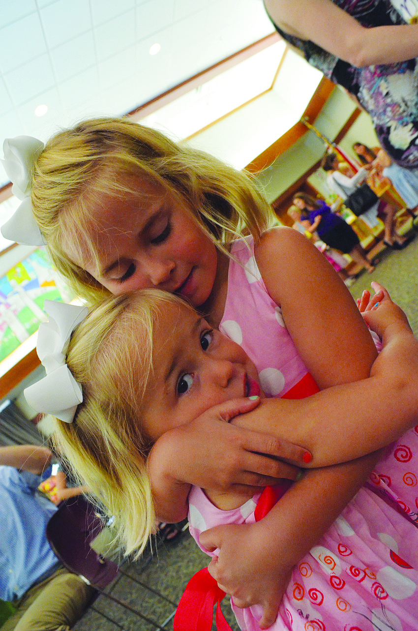 Emerson Miller gives her little sister, Elle, a hug May 17 at First Presbyterian Church of Sarasota's Butterfly Ball.