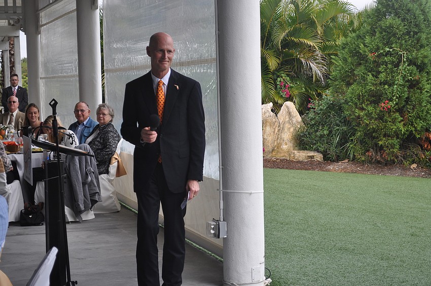 Gov. Rick Scott prepared to hand off the microphone after speaking.