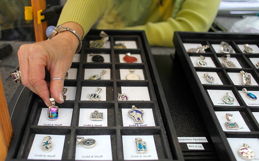 Glenda Lundgren arranges jewelry at her booth, Gold and Stuff.