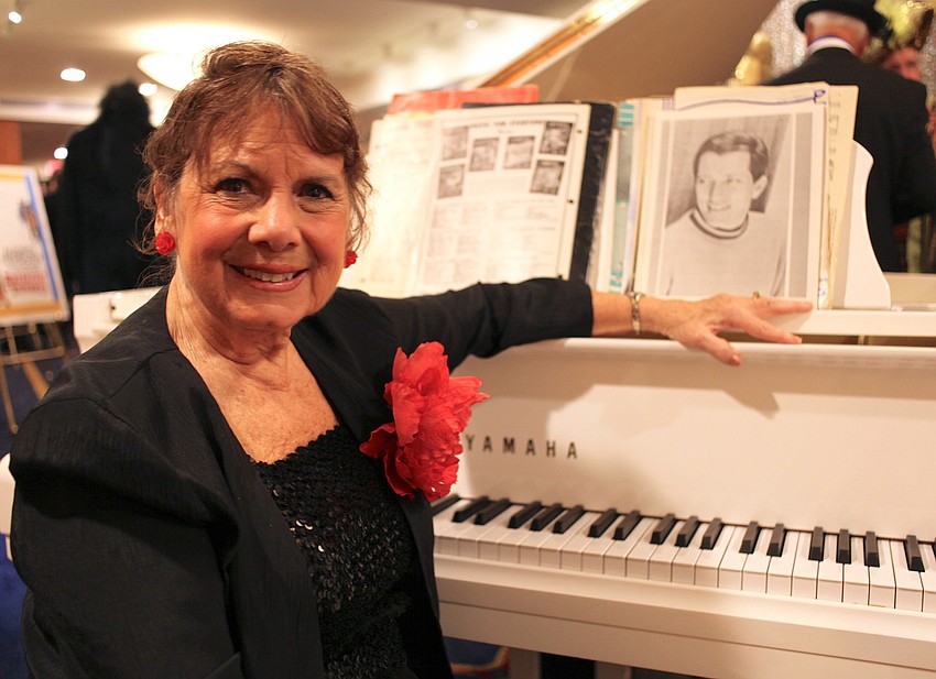 Ann Weber displays a picture of Andy Williams at the piano as she entertains the crowd with classics like â€œMoon River.â€